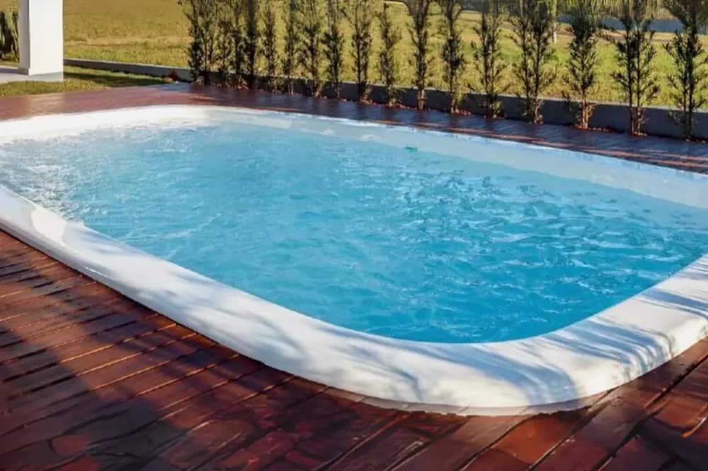 Deck corrido e cerca viva, em piscina de fibra já instalada