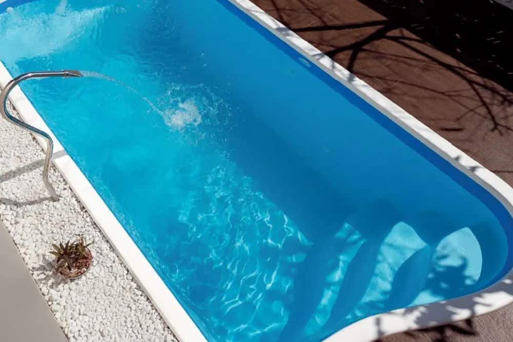 Piscina de fibra instalada, vista de cima, com deck e área de convivência